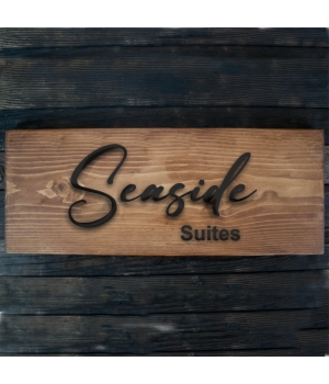 πινακίδα ξύλινη με όνομα ξενοδοχείου με μαύρα επικολλημένα ξύλινα γράμματα