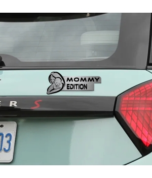 Αυτοκόλλητο Mommy Edition σε μεταλλικό φινίρισμα, με σιλουέτα μητέρας και μωρού, τοποθετημένο στο πορτ-μπαγκάζ ενός ανοιχτόχρωμου αυτοκινήτου.