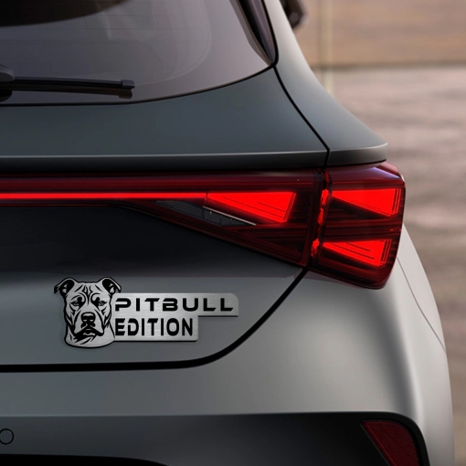 Αυτοκόλλητο Pitbull Edition σε μεταλλικό φινίρισμα, με κεφαλή Pitbull, τοποθετημένο στο πίσω μέρος ενός σκούρου γκρι αυτοκινήτου δίπλα στα φώτα.