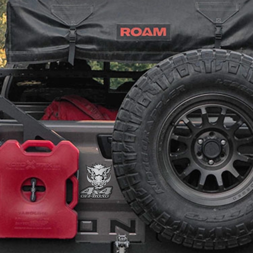 Αυτοκόλλητο Wild Hog 4x4 Off Road, σε μεταλλικό φινίρισμα, τοποθετημένο στο πίσω μέρος ενός 4x4 οχήματος δίπλα σε κόκκινο δοχείο καυσίμων και ρεζέρβα.