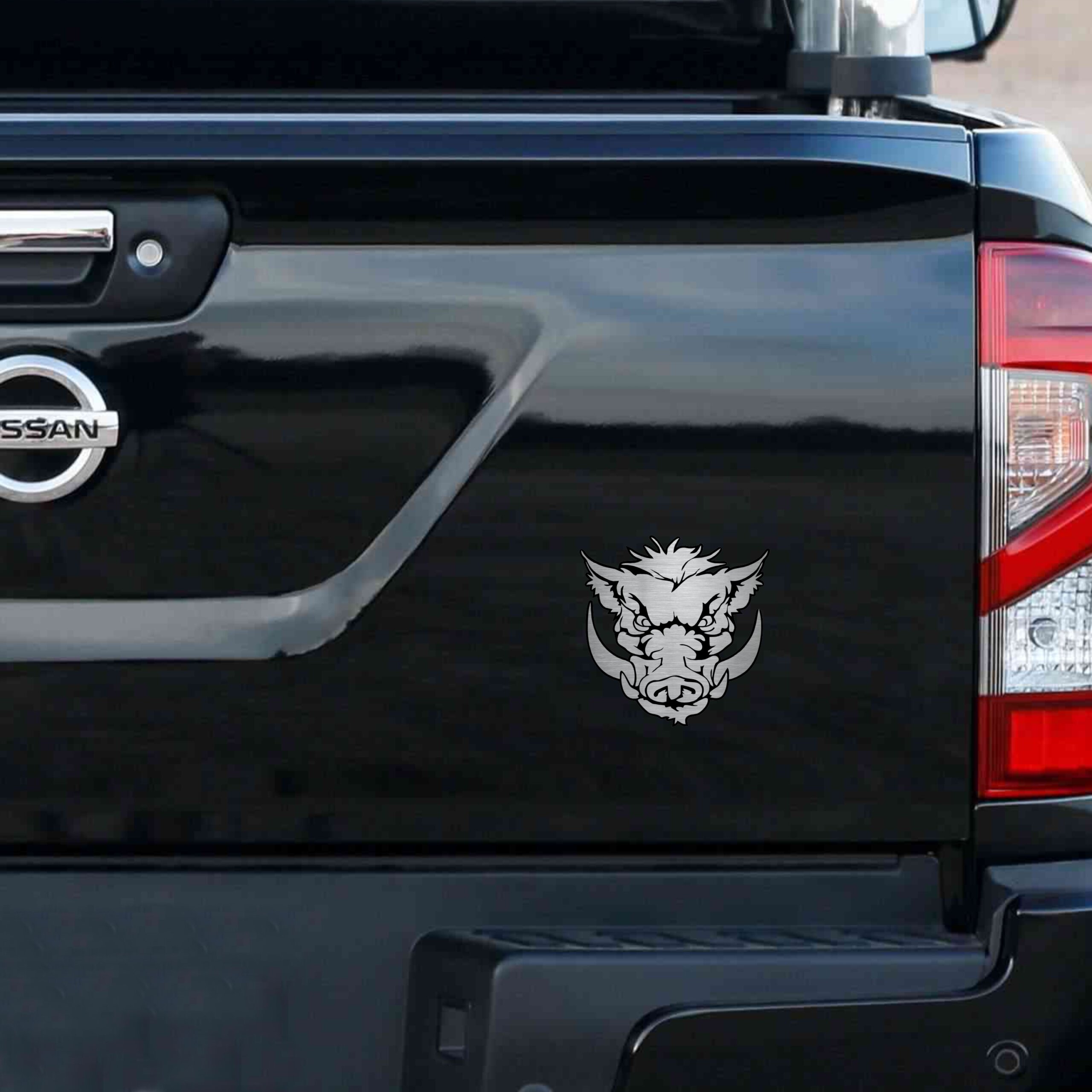 Αυτοκόλλητο κεφαλής Αγριόχοιρου (Wild Hog) με χαυλιόδοντες, σε μεταλλικό φινίρισμα, τοποθετημένο στο πίσω μέρος ενός μαύρου pick-up.