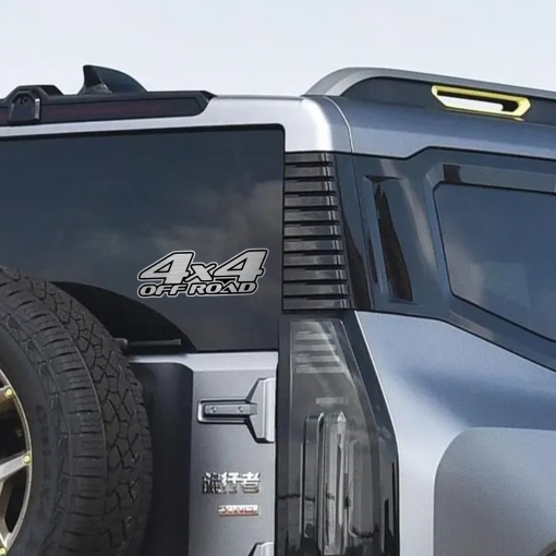 Αυτοκόλλητο 4x4 OFF ROAD σε μεταλλικό φινίρισμα, τοποθετημένο στο πλάι ενός γκρι 4x4 οχήματος, δίπλα στη ρεζέρβα.
