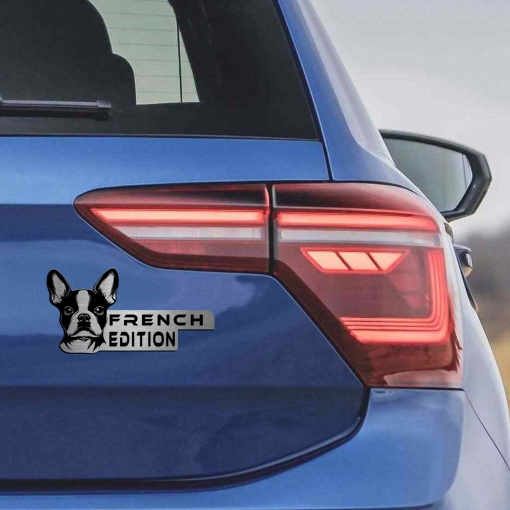 Αυτοκόλλητο French Bulldog Edition σε μεταλλικό φινίρισμα, με κεφαλή Γαλλικού Μπουλντόγκ, τοποθετημένο στο πίσω μέρος ενός μπλε αυτοκινήτου δίπλα στα φώτα.